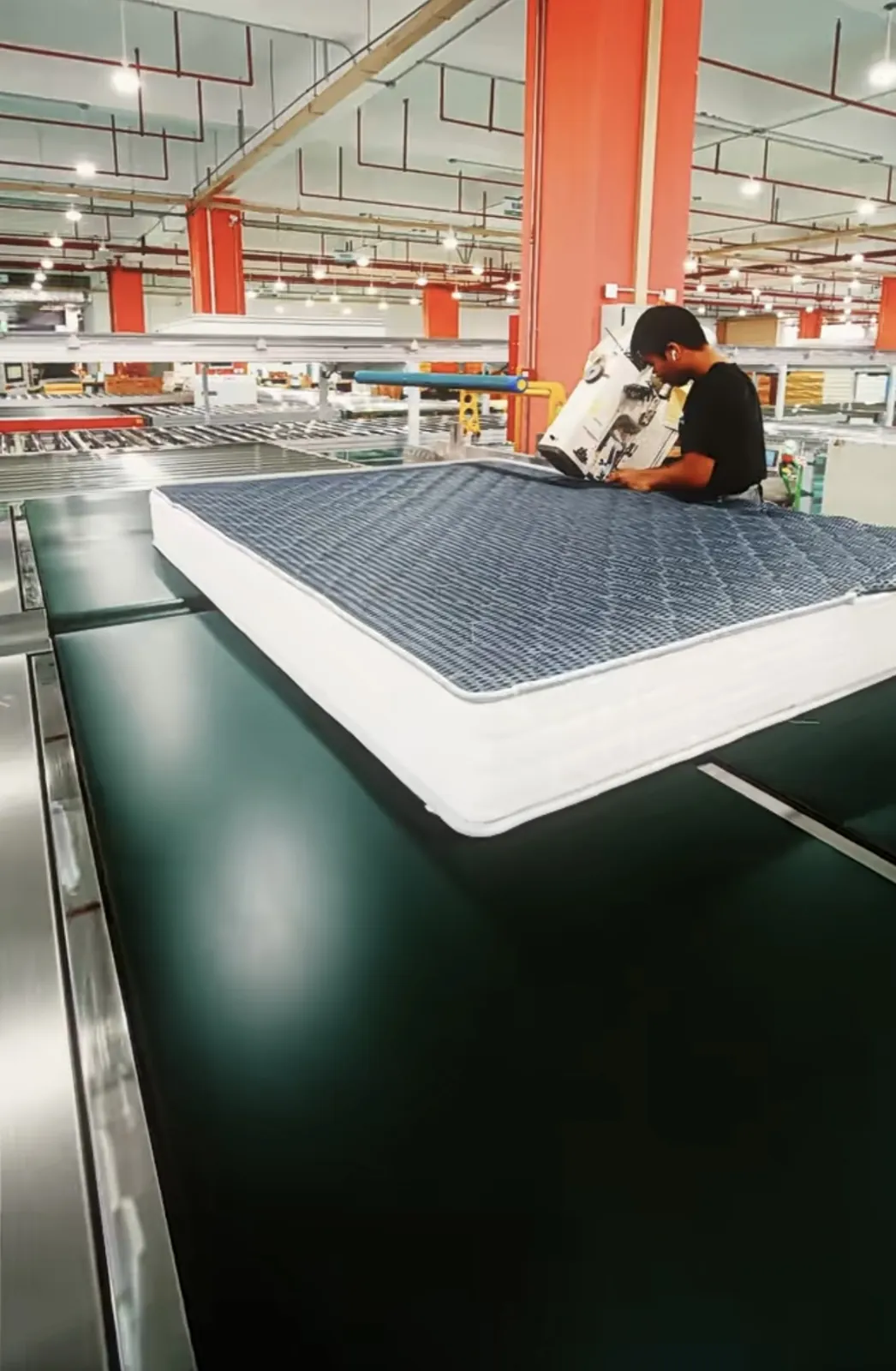 Worker sewing a mattress on the production floor