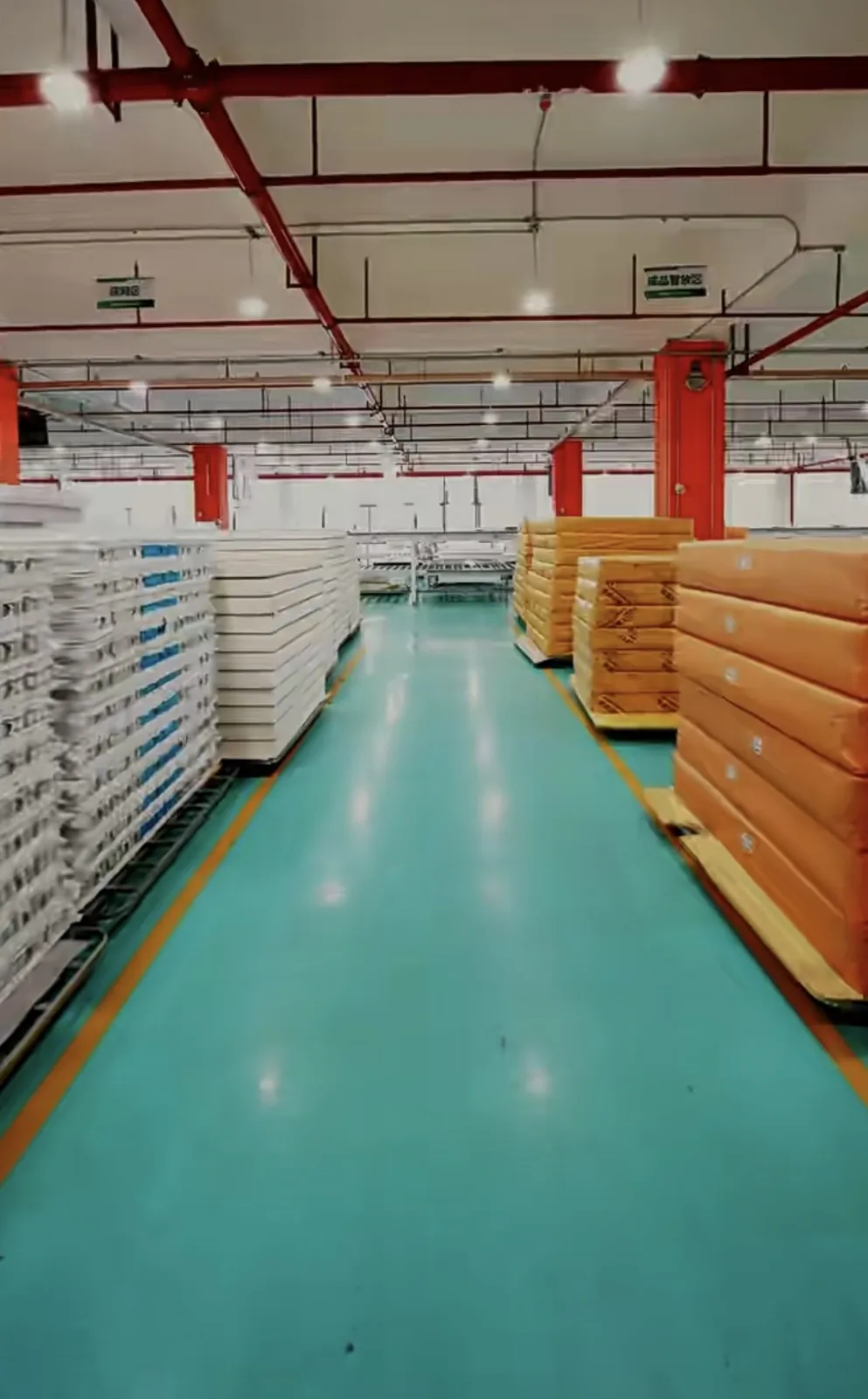 Warehouse aisle with mattresses arranged on pallets